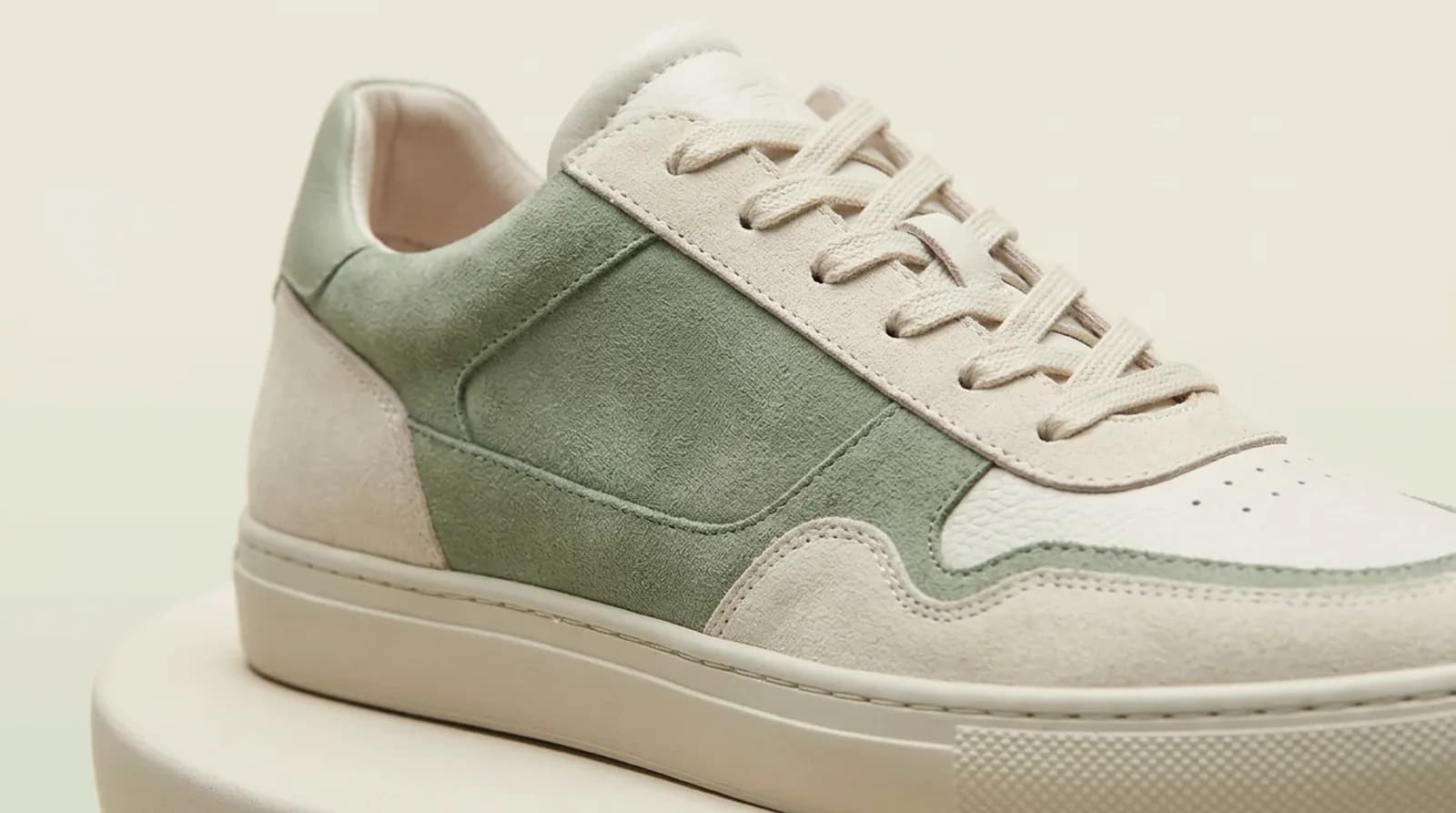 A close-up of the sneaker's laces and suede panel, where a detail sweep ends